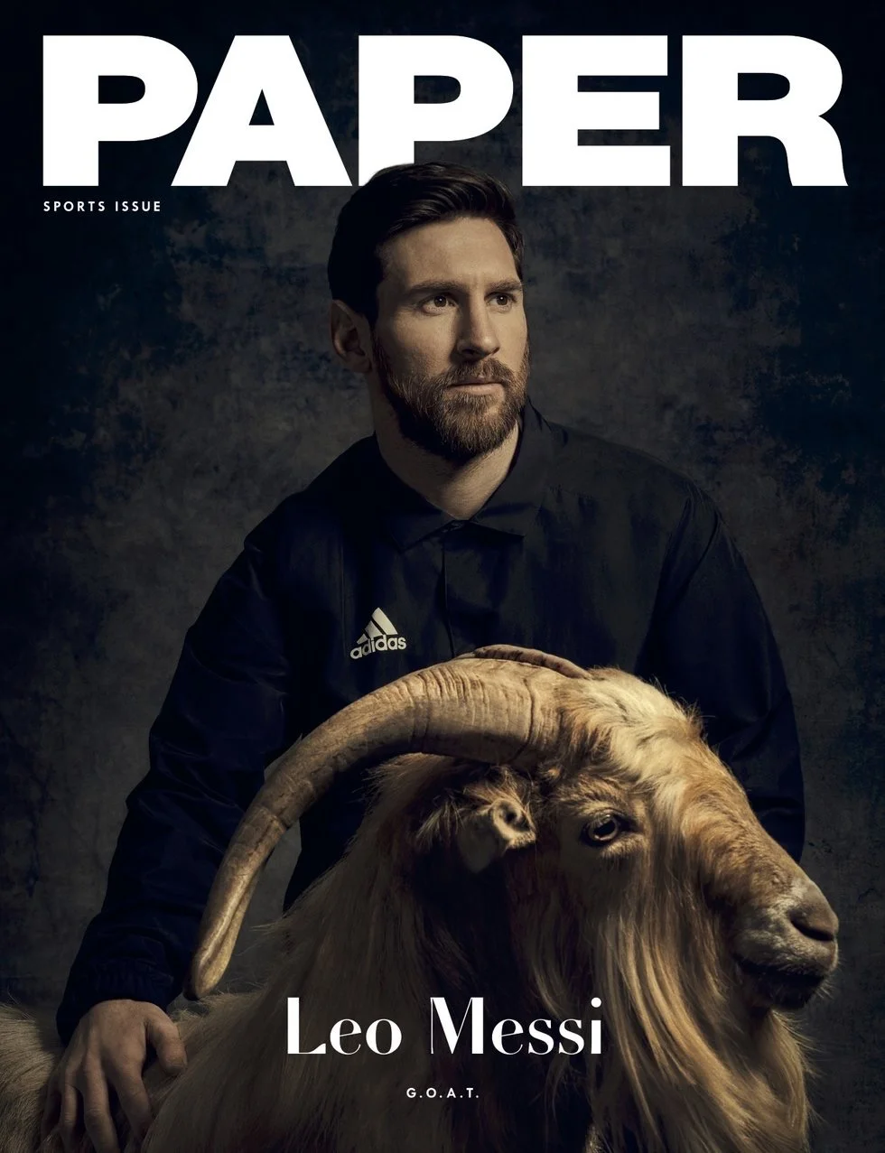 Magazine cover photograph of Lionel Messi in an Adidas jacket resting his hand on a live goat, on a dark backdrop, with the title 'PAPER Sports Issue'.